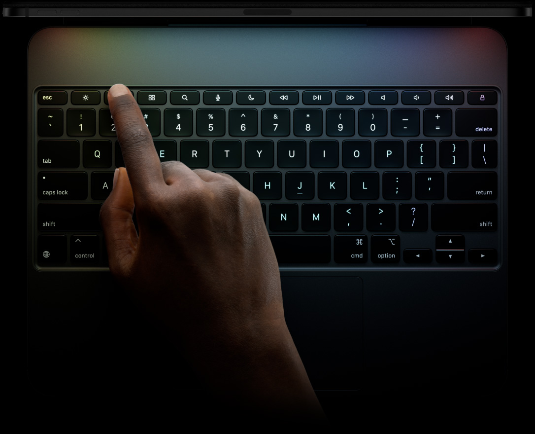 適用於 iPad Pro 的黑色精妙鍵盤，橫向放置，展示專用的功能鍵列、倒 T 形排列的方向鍵和內置觸控板